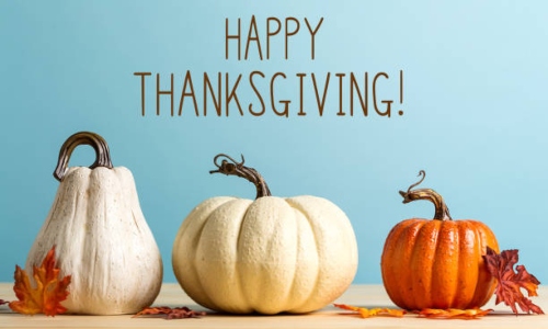 Thanksgiving message with pumpkins on a blue backgroun